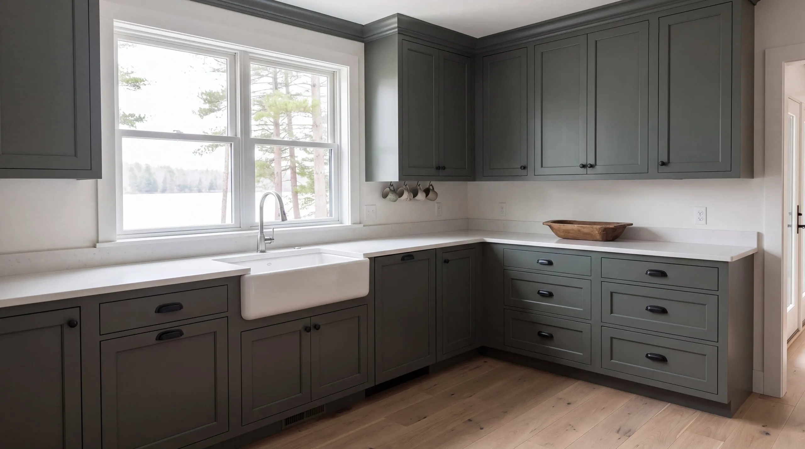 Kitchen with gray-green shaker cabinets, brass pulls and a reclaimed-wood island